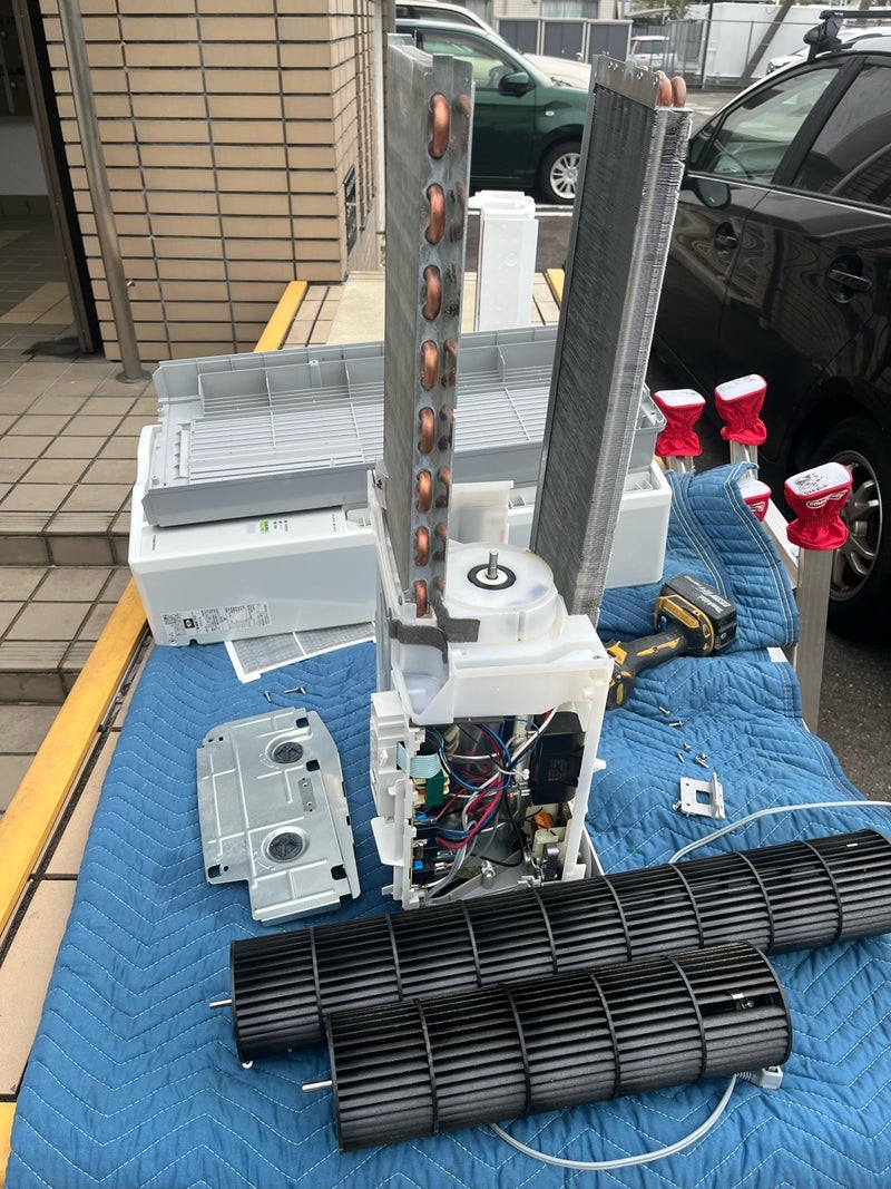 分解した窓用エアコン内部の洗浄作業